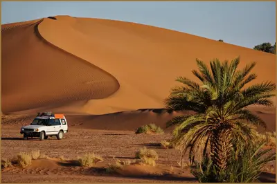a white truck parked in front of a sand dune at Casa Juan in Tagounite