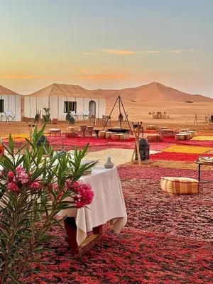 a table in the middle of a desert with tents at Merzouga LUXURY TENT in Merzouga