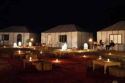 a group of tents with lights in the dark at Merzouga LUXURY TENT in Merzouga