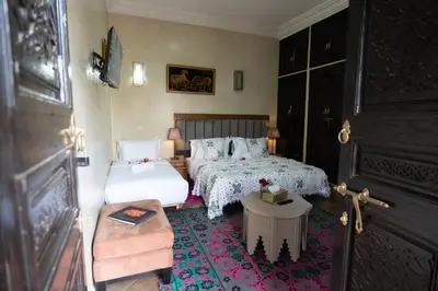 a small bedroom with two beds and a table at Riad Rayhana De L Atlas in Ourika