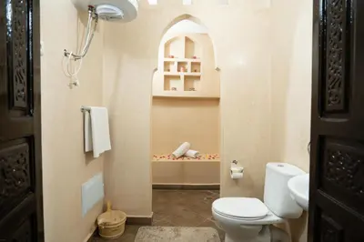 a small bathroom with a toilet and a shelf at Riad Rayhana De L Atlas in Ourika