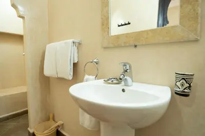 a bathroom with a white sink and a mirror at Riad Rayhana De L Atlas in Ourika