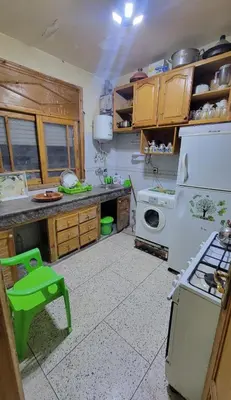 a kitchen with a white refrigerator and a stove at Apartment low price good location in Fès