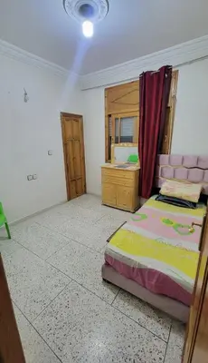 a bedroom with a bed and a dresser in it at Apartment low price good location in Fès