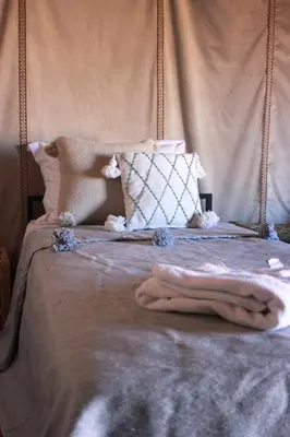 a bed with a blanket on top of it at Bivouac Le secret des dunes, lac Iriqui in Foum Zguid