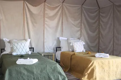 a room with two beds with towels on them at Bivouac Le secret des dunes, lac Iriqui in Foum Zguid