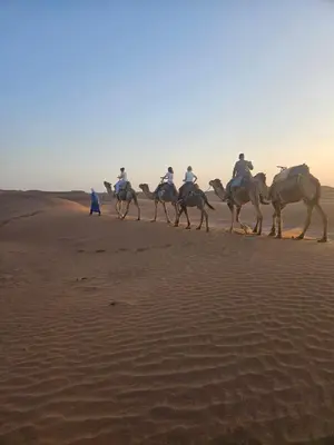 a group of people riding horses in the desert at Bivouac Le secret des dunes, lac Iriqui in Foum Zguid