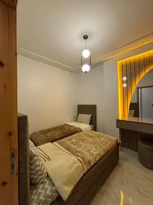 a bedroom with two beds and a mirror at إقامة جنان كاميليا مكناس in Douar Sidi Cherki