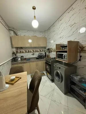 a kitchen with a stove and a washing machine at إقامة جنان كاميليا مكناس in Douar Sidi Cherki