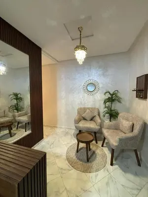 a lobby with two chairs and a table and a chandelier at إقامة جنان كاميليا مكناس in Douar Sidi Cherki