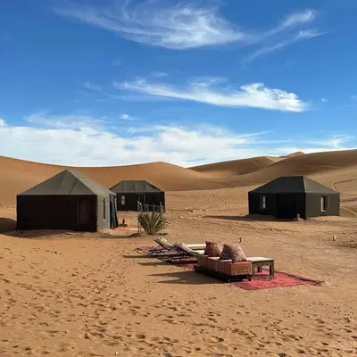 a group of tents in the middle of a desert at Sahara pathfinders in Mhamid