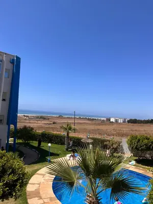 a view of a swimming pool with the ocean in the background at Sublime appartement front de mer in Oulad Akkou