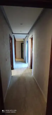 an empty hallway of an empty room with doors and a hallway at Sublime appartement front de mer in Oulad Akkou