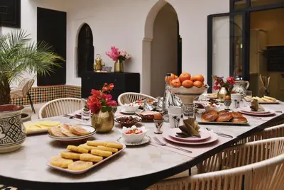 a long table with food and snacks on it at Riad Arraha Retreat Elegance tranquility and pools in Marrakech