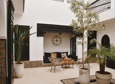 a patio with plants and a couch and a table at Riad Arraha Retreat Elegance tranquility and pools in Marrakech