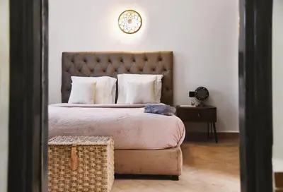 a bedroom with a large bed and a clock on the wall at Riad Arraha Retreat Elegance tranquility and pools in Marrakech