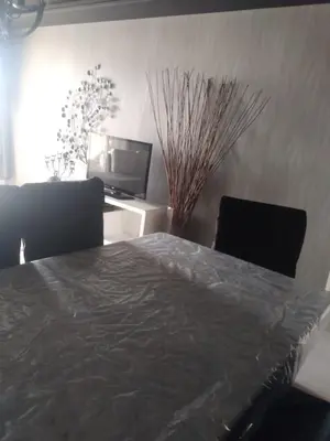 a bedroom with a bed and two chairs and a television at Bir jdid in Oulad Akkou