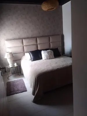a bedroom with a large bed with a large headboard at Bir jdid in Oulad Akkou