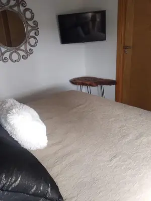 a bedroom with a bed with a pillow and a mirror at Bir jdid in Oulad Akkou
