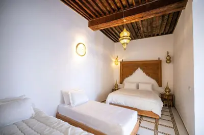 a bedroom with two beds and a couch at Riad Old City Palace in Fès