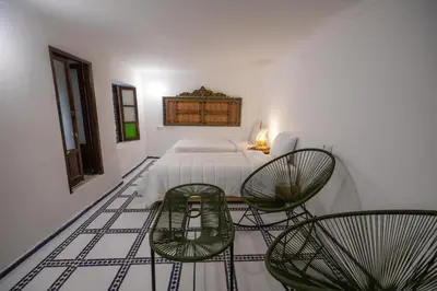 a bedroom with a bed and two chairs at Riad Old City Palace in Fès