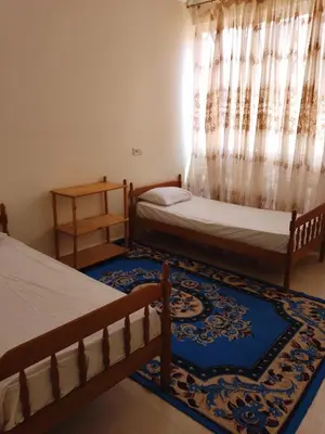 a bedroom with two beds and a rug at إقامة المنظر الجميل in Oulad Akkou