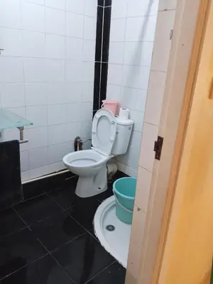 a bathroom with a toilet and a bucket at إقامة المنظر الجميل in Oulad Akkou