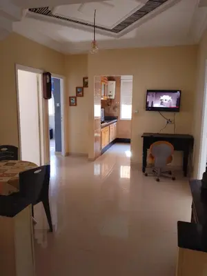a living room with a television and a table at إقامة المنظر الجميل in Oulad Akkou
