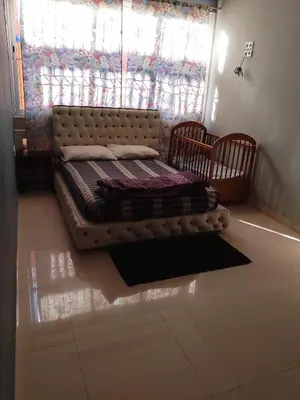 a bed sitting in the corner of a room with a window at إقامة المنظر الجميل in Oulad Akkou