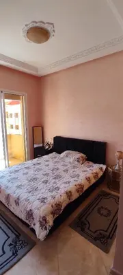 a bedroom with a bed with a comforter on it at Bouznika in Oulad Akkou