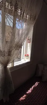 a room with a window with a curtain on it at Bouznika in Oulad Akkou