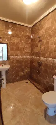 a bathroom with a shower and a toilet and a sink at Bouznika in Oulad Akkou