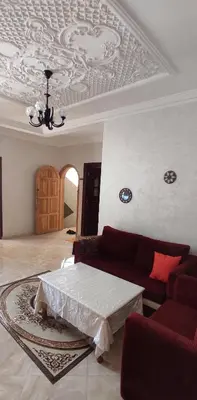 a living room with a couch and a coffered ceiling at Bouznika in Oulad Akkou