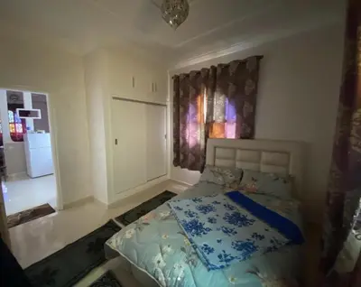 a bedroom with a bed with a blue comforter at Dar Ezzaouiya in Ouzoud