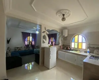 a kitchen and living room with a refrigerator and a couch at Dar Ezzaouiya in Ouzoud