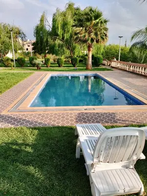 a swimming pool with a bench and a chair next to it at Ferme fes in Oulad Tayeb