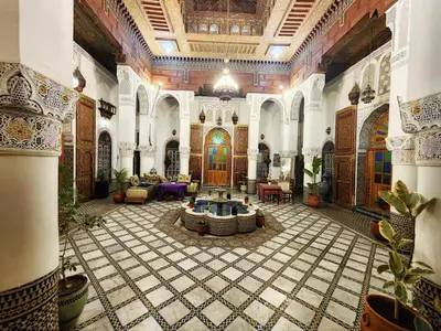 a large room with a tile floor and a building at Riad el Anaqa in Fès