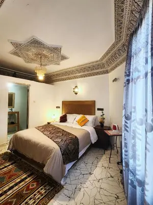 a bedroom with a bed and a coffered ceiling at Riad el Anaqa in Fès