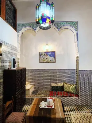 a room with a table and a chandelier at Riad el Anaqa in Fès