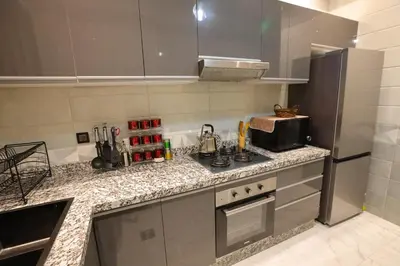a kitchen with a counter with a stove and a microwave at Résidence Meknes Appt F4 in Meknès