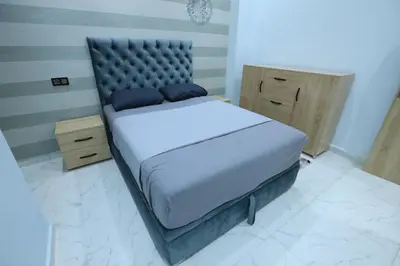 a bedroom with a large bed with a padded headboard at Résidence Meknes Appt F4 in Meknès
