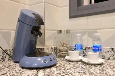 a blue coffee maker sitting on a counter with cups at Résidence Meknes Appt F4 in Meknès