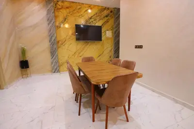 a dining room with a wooden table and chairs at Résidence Meknes Appt F4 in Meknès