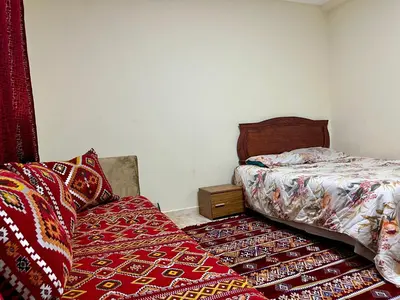 a bedroom with a bed and two rugs on the floor at Saha khedra in Oulad Akkou