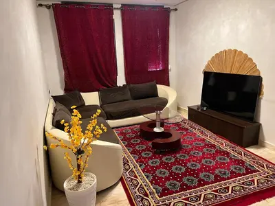 a living room with a couch and a tv at Saha khedra in Oulad Akkou