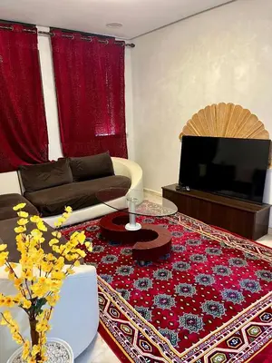 a living room with a couch and a television at Saha khedra in Oulad Akkou