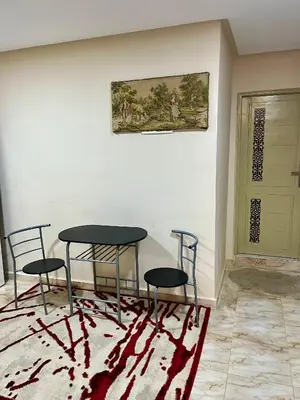 a room with two chairs and a table and a painting at Saha khedra in Oulad Akkou