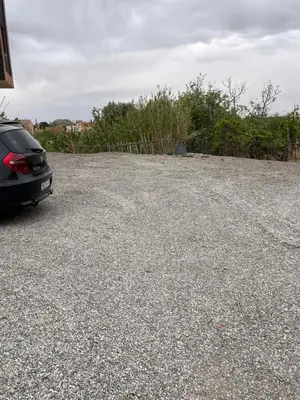 a black car parked in a parking lot at Saha khedra in Oulad Akkou