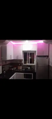 a kitchen with white cabinets and purple lighting at الحي المحمدي أكادير in Oulad Akkou