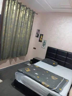 a bedroom with a bed and a couch and a window at الحي المحمدي أكادير in Oulad Akkou